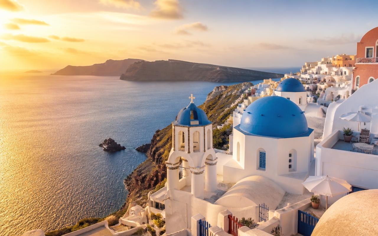 Blue-domed churches of Santorini, Greece at sunset